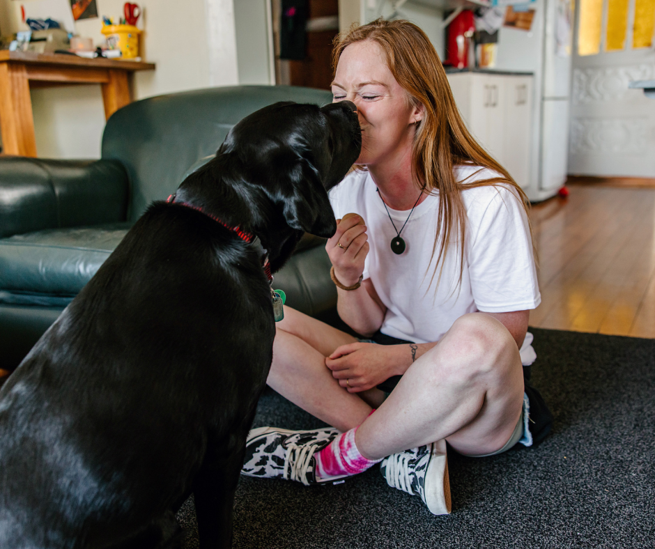 Laura touching noses with her black guide dog, Ryder. Laura touching noses with her black guide dog, Ryder.