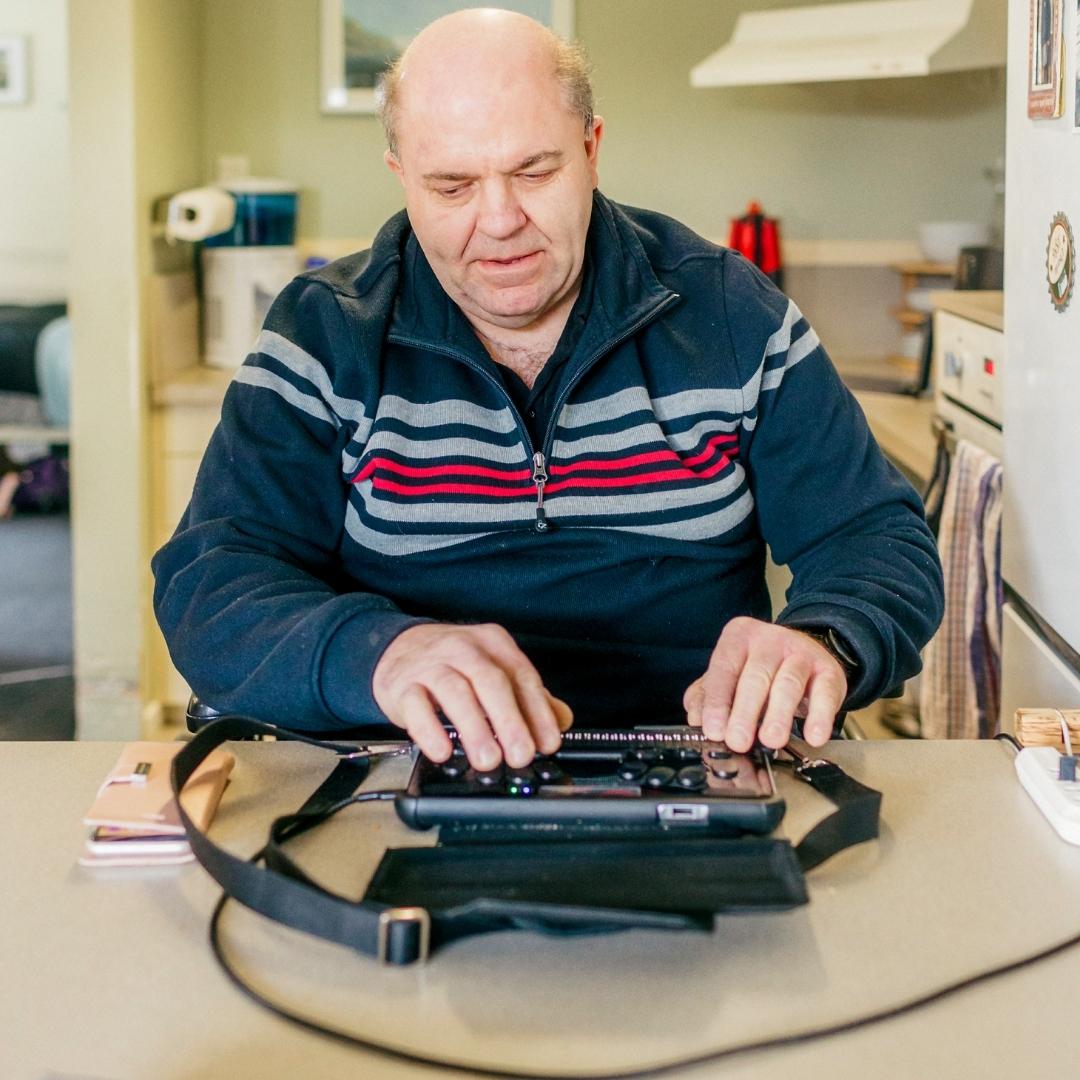 A man using a Braille machine A man using a Braille machine